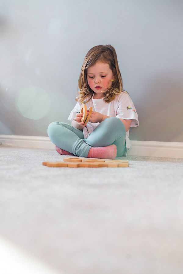 Little girl sitting on comfy carpet